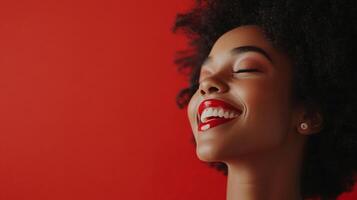 Radiant woman with red lips and her eyes closed, beaming with joy against a matching red background. A picture of pure happiness. photo