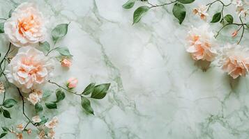 Floral arrangement featuring peach flowers and verdant leaves on a marbled surface, creating a soft, elegant and natural aesthetic. photo