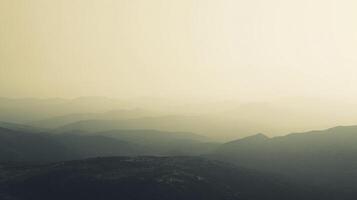 Layered mountain range receding into the horizon, with hazy light creating an ethereal landscape view, featuring peaks and valleys. photo