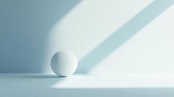 A single, matte white sphere rests on a plain, pale blue surface, bathed in soft, angled light creating a minimalist and calming atmosphere. photo