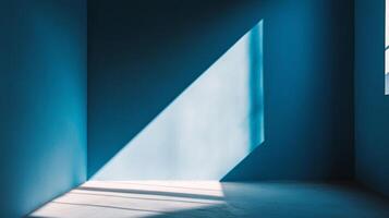 Sunlight streams through a window, casting a sharp geometric shadow on the blue wall and floor, creating an abstract and tranquil scene. photo