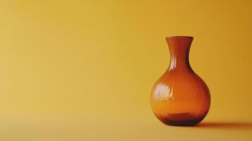 Amber-toned glass vase standing against a simple yellow background, a display of minimalist aesthetics and warm color tones. photo