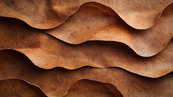 Earthy brown waves of texture and tone that feel like soft, aged leather create a serene, organic pattern. Gentle light emphasizes its depths. photo