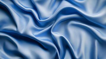 Close up of a light blue, silky fabric with soft folds and curves, creating an elegant and luxurious texture and a smooth surface. photo