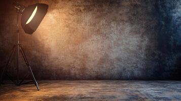 A studio lighting setup illuminates a textured backdrop. A single light stands on a tripod, casting a warm glow on the backdrop. photo