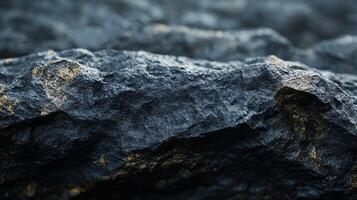 Dark rock formation with gold flecks. Natural surface patterns texture. Atmospheric stone close-up reveals weathering and mineral deposits. photo