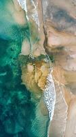 Aerial view of beach with crashing waves and natural landscape photo