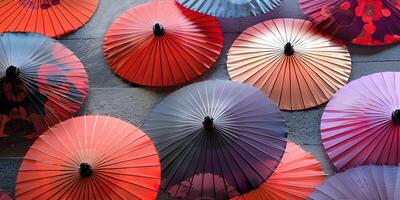 A collection of vibrant umbrellas lie scattered like petals on the ground photo