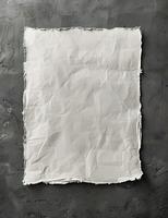 A torn paper rests on a grey surface in a monochrome photography event photo