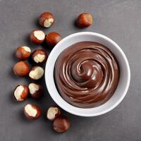 Chocolate cream with hazelnut, soft paste in a bowl. Dark chocolate, cocoa. Close-up food image isolated, top view. Design element photo