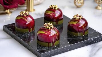 Four chocolate covered balls on a black tray photo