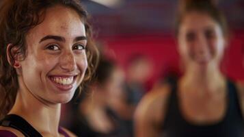 A smiling woman in a gym with other people in the background photo