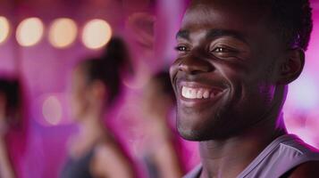 A man smiles while standing in front of a group of people photo