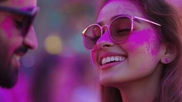 A man and woman are smiling while covered in pink paint photo
