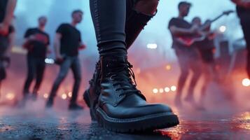 A person wearing black boots standing in front of a crowd photo