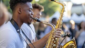 A man playing the saxophone at an outdoor event photo