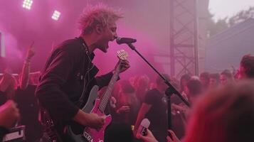 A man with a guitar on stage at a concert photo
