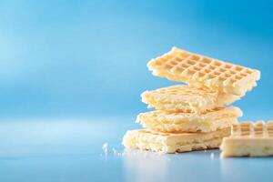 A stack of light wafers on a blue background, showcasing texture and color. photo