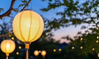 Illuminated paper lanterns hang in a serene evening setting. photo