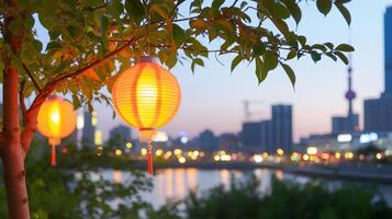 Lanterns hanging from a tree by a river at dusk in a cityscape. photo