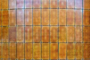 Rustic metal panels create a striking textured wall in an urban environment during the afternoon light photo