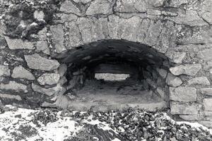 Stone archway reveals interior of historic structure nestled in snowy landscape during winter afternoon photo