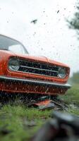 An orange car is sitting in the rain photo