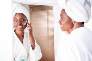 Refreshing Skincare Routine A Woman Joyfully Applying Cream in Front of a Mirror photo