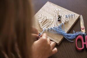 Close-up of a child hands creating string art. Enhancing concentration, creativity, and sensory skills photo