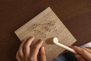 Child hands working on a wooden craft project. Using a hammer, learning skills, and exploring creativity. photo