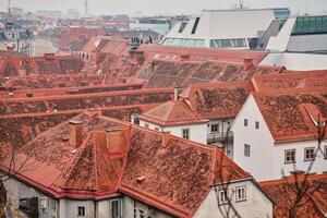 Scenic aerial view of historic European rooftops covered with red clay tiles and chimneys. Old town architecture and traditional cityscapes in European city. Panoramic view of Graz, Austria photo