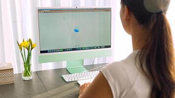 Prague, Czech republic - February 24, 2025. Back view of woman working on iMac with Chat Gpt application on screen. Work assistant with Open Ai. Artificial Intelligence concept. video