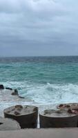 uma tormentoso mar com falhando azul ondas debaixo Sombrio nuvens perto a costa do budva Montenegro. a poderoso oceano incha e dramático céu crio uma tirar o fôlego exibição do naturezas força. video
