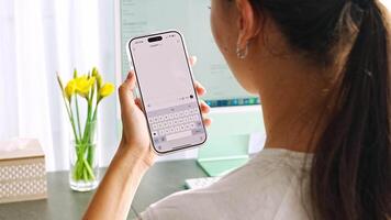 Prague, Czech republic - February 24, 2025. Back view of woman holding Iphone with Chat Gpt application on screen. Work assistant with Open Ai. Artificial Intelligence concept. video