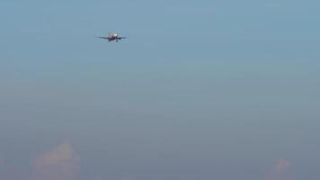 Plane approaching landing, front view. Jet plane with unrecognizable livery descending, arriving. Aircraft in the blue sky video