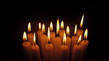 A peaceful collection of gently lit candles emanating warm, soft light against a dark, contrasting backdrop video
