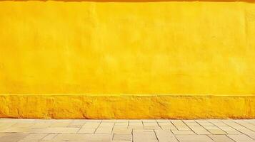 An exterior view of a vibrant yellow wall paired with a neutral stone sidewalk, creating a striking contrast of color and texture. photo
