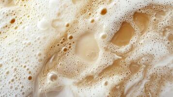 Close-up view of a beverage with creamy foam and liquid. The bubbles create interesting textures and patterns. Creamy, cozy, and warm aesthetic. photo