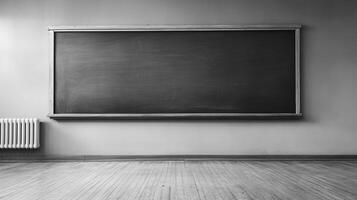 Monochrome classroom featuring a large, empty blackboard mounted above a radiator, setting a stage for learning and academic endeavors. photo