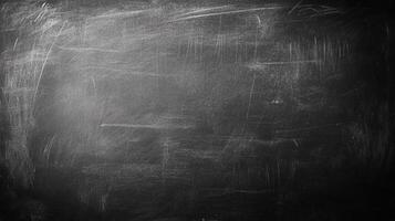 Worn chalkboard with streaks of white chalk dust, creating a textured dark background with subtle gradations in tone across the surface. photo