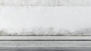 Urban decay meets clean lines. A textural white wall stands above a modern stone sidewalk, creating a study in contrast and simplicity. photo