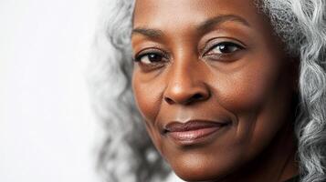 Close-up portrait of a confident woman with gray hair, radiating wisdom and grace in a simple, clean setting. Smiling slightly. photo