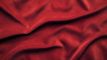 A close-up of rich, deep red fabric with soft, natural folds and subtle light play. A captivating texture for design projects. photo