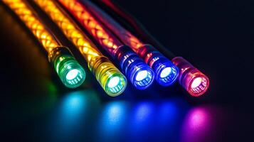 Close-up of vibrant optical fibers emitting colorful light in a dark setting, creating a visually appealing technological display. photo