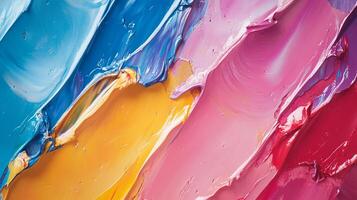 Macro view of vibrant oil paint strokes featuring shades of blue, yellow, pink, and red on canvas showing texture and artistic expression. photo