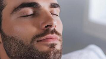 Man with closed eyes, peaceful expression, and a well-groomed beard, conveying a sense of relaxation and serenity. Closeup shot. photo