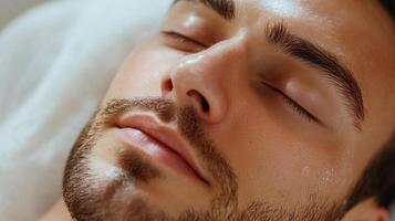 Relaxing skincare treatment at a spa. Man with eyes closed is receiving skin therapy on a white pillow during a cosmetic procedure. photo
