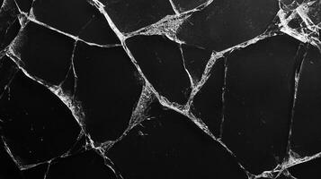 Fractured surface with jagged, chaotic lines. Shiny fissures create a web-like design on a dark background, symbolizing fragility. photo