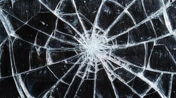 Cracked surface pattern shows radiating web of fracture lines on a dark background. A central point with radiating breakage. photo