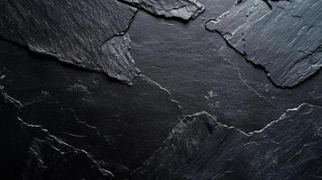 Dark and textured slate rock formation showing abstract shapes and patterns. Ideal for graphic design or background textures. photo